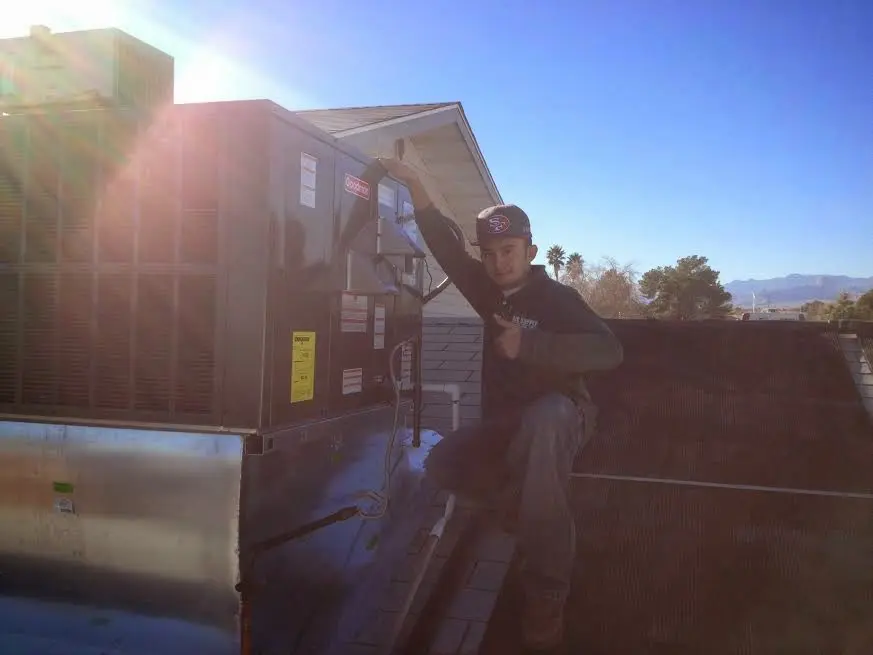 HVAC technician performing Heat Pump Repair on a rooftop unit in Carthage